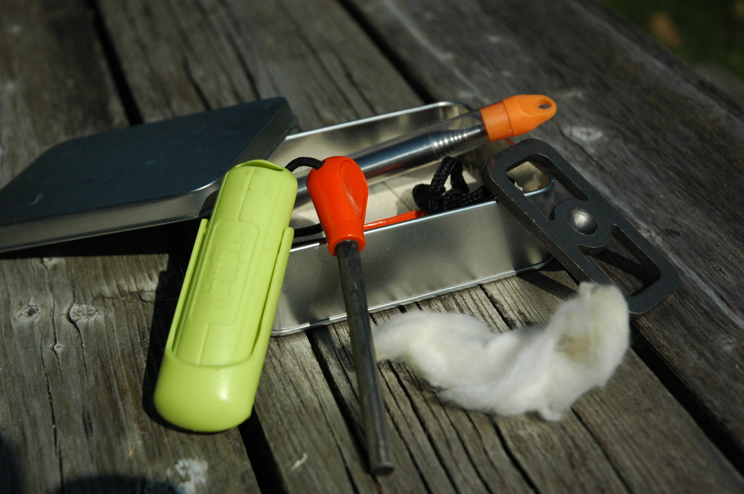 An emergency fire kit flat-lay featuring a ferro rod essential for the Canadian wilderness trail.